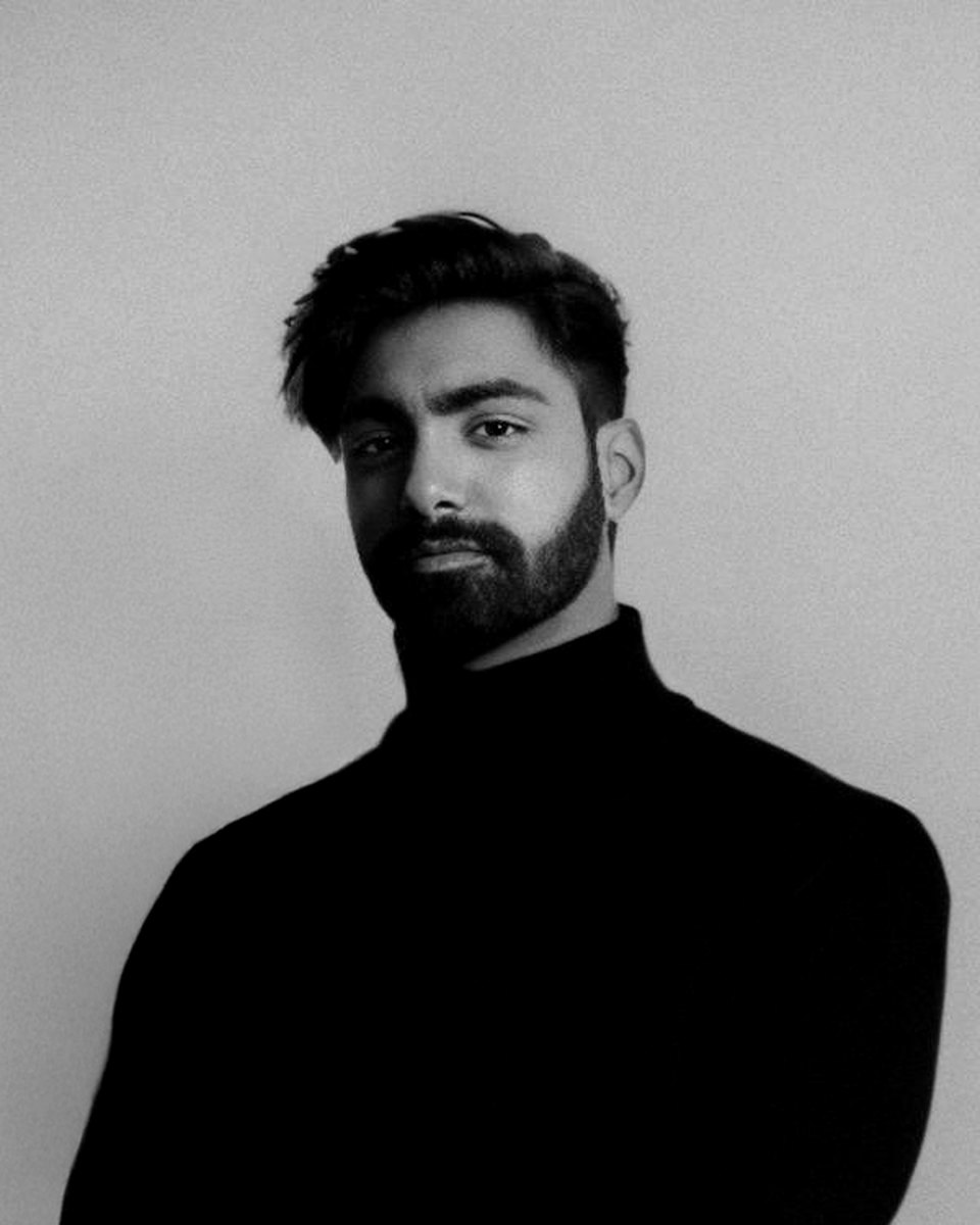 Saurabh Khanwani, in a black turtleneck against a white arched backdrop